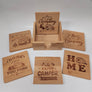 Five wood-looking square coasters surround the wood box with the sixth coaster inside it. Camp saings are letter into the wood along with classic camper images.
