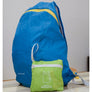 Blue back back opened up for display behind the green packaging of a folded backpack.