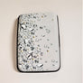 Cover of the closed rfid powerbank wallet. White background with small faceted glass circles spreading out from the left side.