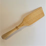 Single light wood-grain spatula on a white background.