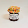 Colorful yellows and orange flowered cloth banded to a jar of Gonyo Farms Apricot Hot Pepper Jam.