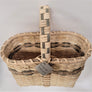 Looking inside the woven wine basket. Neutral color with olive and taupe trim in top third of basket and olive trim mixed in with handle above the basket.