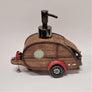 Woody camper soap dispenser in profile. The left side even includes the connection segment that leads to the pulling vehicle. the right sides shows the slightly open hatch.