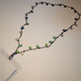 Lanyard chain featuring fishing lures with lots of green and blue glass spread out flat attached by hook to a plastic ID holder.