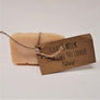 Single bar of Goat's Milk Natural soap standing upright with beige twine circling the center holding the beige label.