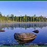 Just the horizontal photograph taken from the box cover. Blue water with a gold canoe in front of flat land with sold evergreen covering stretched into a foggy background.
