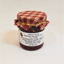 Red plaid cloth banded to a jar of Gonyo Farms Raspberry Hot Pepper Jam.