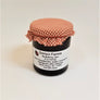 ColorRed-checkered cloth banded to a jar of Gonyo Farms Raspberry Jam.