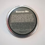 Bottom of the Rescue Me circular tin with text on what it is made from on a gray background.