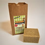 Small brown bag with SallyeAnder No-Bite-Me label on front. Pictured is a child with chin in the air and fishing pole on shoulder. Black text on a green gingham pattern. Flat in front on the right side is a square bar of the soap. Beige with dark brown specs.
