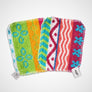 Two Skoy scrubs, one on top of the other. Top one shows vertical patterns of red, blue, pink, white and green; bottom one similar vertical pattern with more green and gold showing.