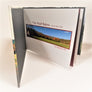 The Red Barn book standing and open to the inside horizontal spread of the blue sky and Adirondack autumn landscape with the Red Barn off to the far left