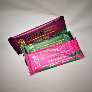 Three colorful chocolate bars in their packaging, maroon balck raspberry pepper; green espresso; pink cherry from Barkeater chocolates
