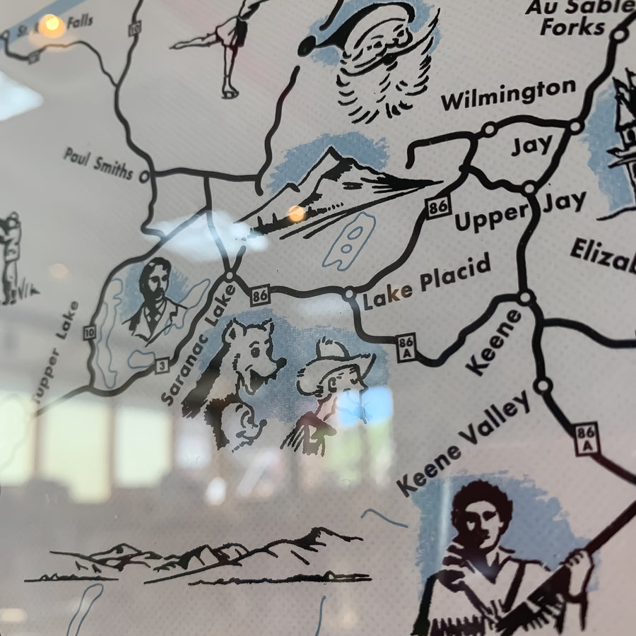 close up of map inset with black lines delineating and drawings of people and animals.
