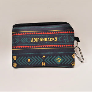 Travel wallet pouch with black zipper top, silver carabiner hangs from right side.  Yellow lines, red triangles, green arrows and ADIRONDACKS in yellow  band on top with various yellow paw prints in the bottom section.