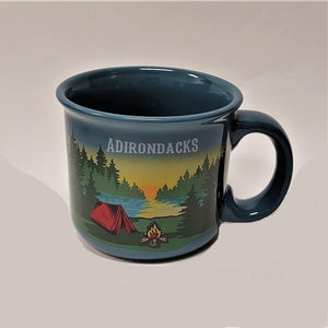 A single turquoise mug with the handle out to the right. The word ADIRONDACKS is printed in white over the image of a setting sun in the back ground with evergreens and water in the mid-section and a red tent, campfire and greenery in the foreground.
