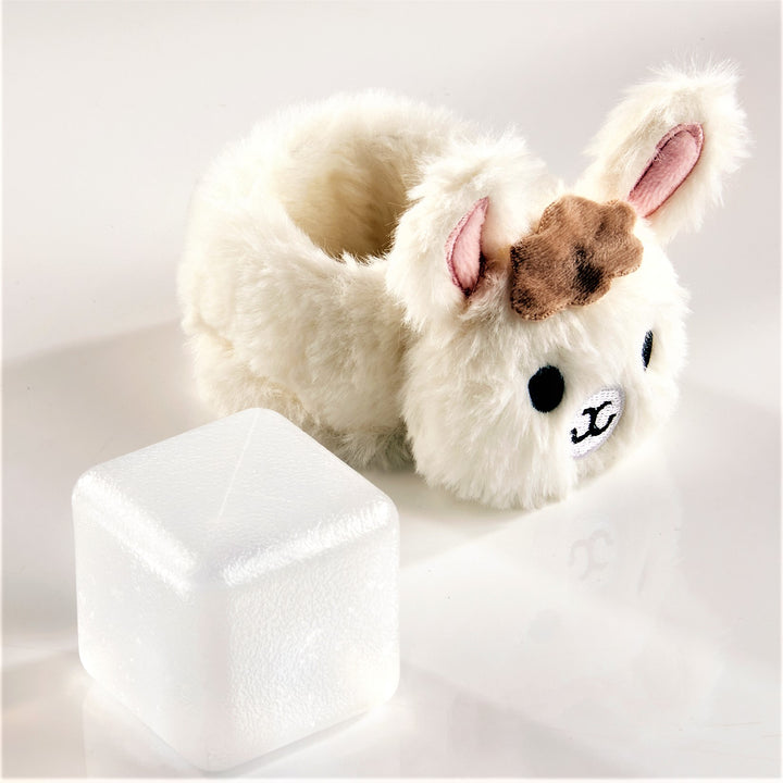 Furry white bunny with hole in the body, pink inner ears, brown fur over two black eyes and white and black nose, alongside a white cube.