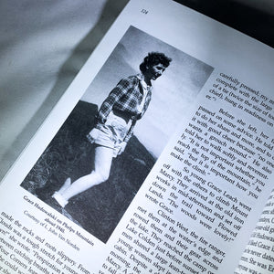 Diagonal of page 124 of the book Breaking Trail with a photo of Grace Hudowalski on Phelps Mountain and some of the text from the page