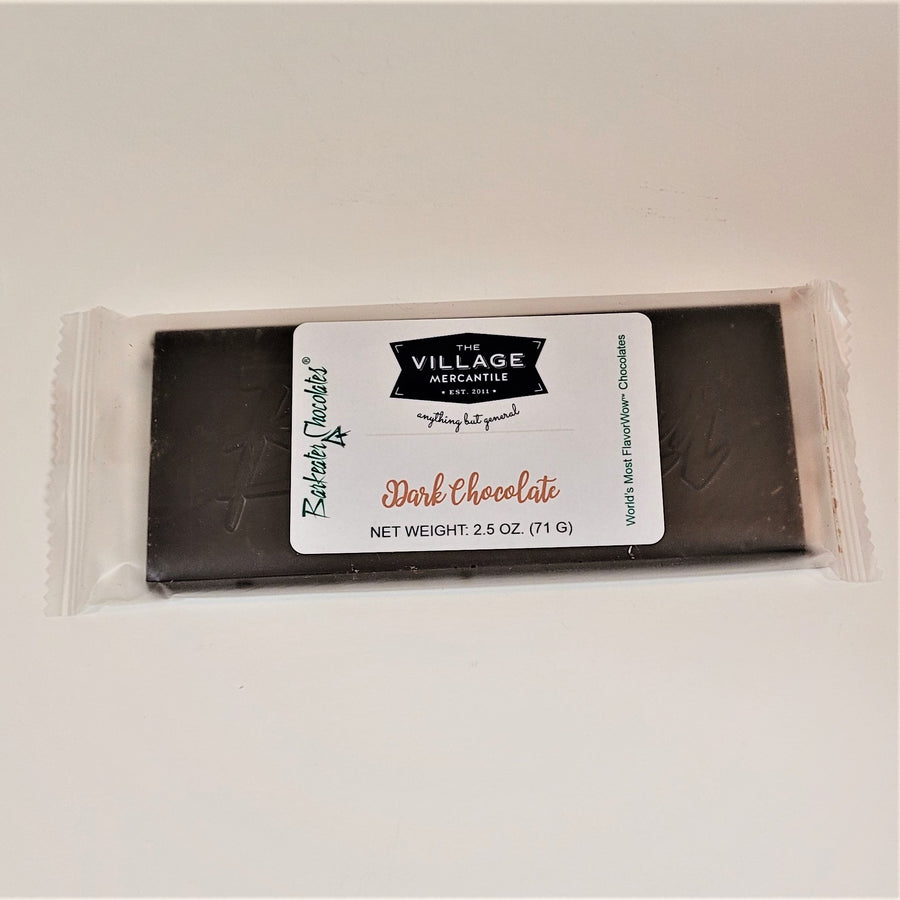 Dark chocolate bar in clear wrapping with the white label in center: The Village Mercantile. Barkeater Chocolates in green type on left side.