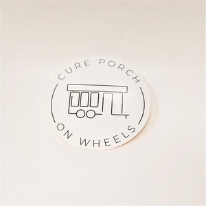 White, round sticker with black type and line art of cure porch on wheels in the center.