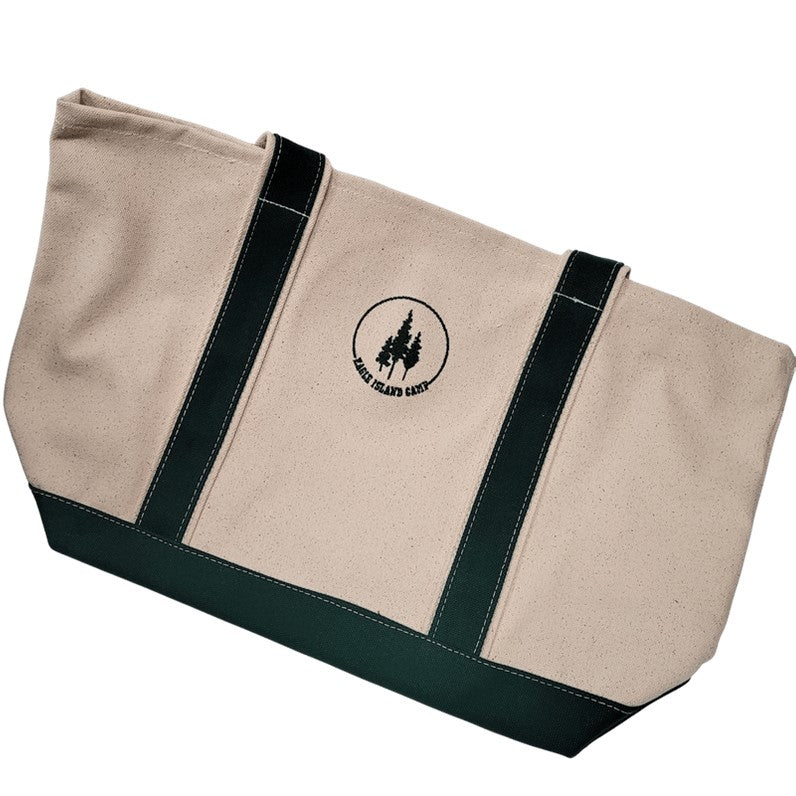Canvas tote with green straps and bottom panel. Centered between the straps is the Eagle Island Camp logo with 3 pine trees centered in a green arc with the EAGLE ISLAND CAMP lettering filling the circle.