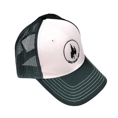 Trucker cap facing out on an angle. Green mesh back with a white front and green Eagle Island Camp logo centered on bottom of the solid white panel. The logo has three green pine trees encircled on top with a green arc and on the bottom with green lettering EAGLE ISLAND CAMP. The hat brim is solid green with six rows of u-shaped white thread sewn around.