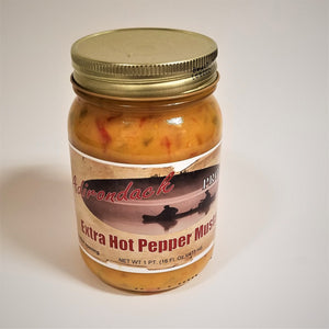 Clear jar of Extra Hot Pepper Mustard with Adirondack Provisions label in the front center. Yellow mustard with red pepper specks show through the clear jar above the label. Gold screw top.