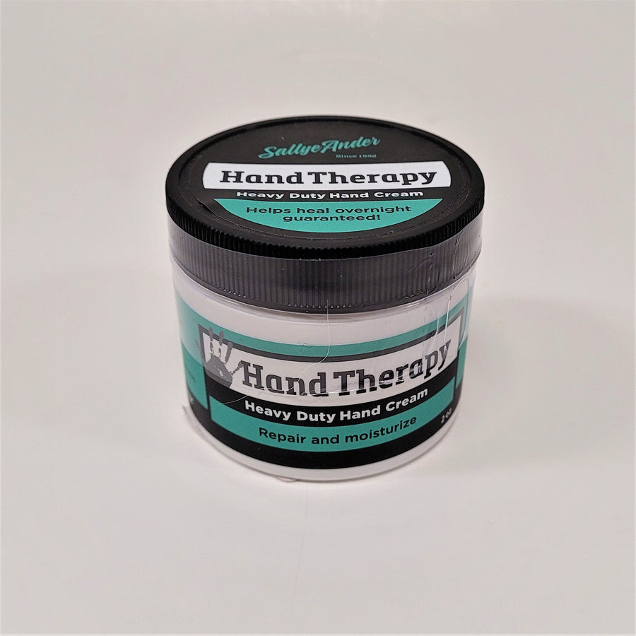 White round container with black twist lid. The labeling is green and black with a gray hand print to the left of the words Hand Therapy. 