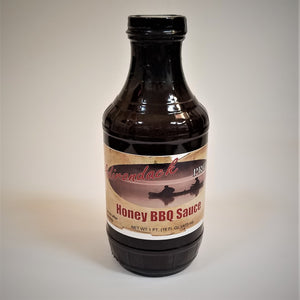 Glass bottle of Honey BBQ Sauce. The dark, rich sauce gives the glass bottle its color under the black screw top.