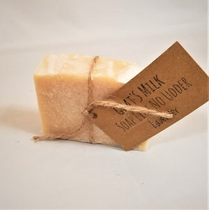Single bar of Goat's Milk Lavender soap standing upright with beige twine circling the center holding the beige label.