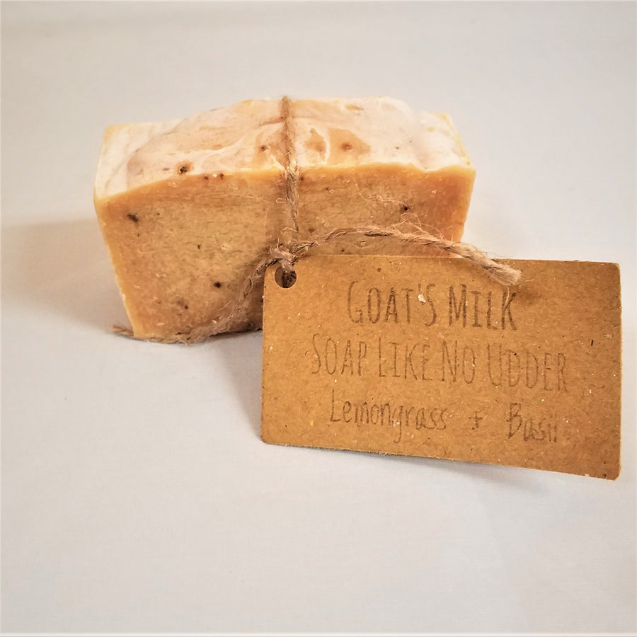 Single bar of Goat's Milk Lemongrass & Basil  soap standing upright with beige twine circling the center holding the beige label.