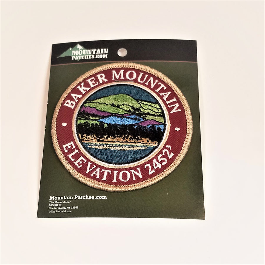 Single patch with a brown circle border and white embroidered text reading BAKER MOUNTAIN ELEVATION 2452, with mountain scene embroidered in circle in a circle.