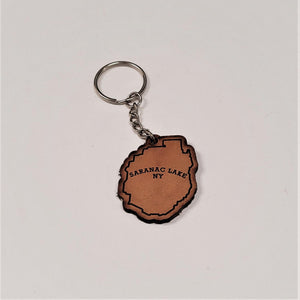 Single leather key chain with SARANAC LAKE NY in brown lettering within the park outline, attached to a silver chain and keyring.