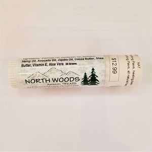 Tube of Northwoods paw balm on its side on a white background. The Northwoods logo is seen below a list of ingredients.
