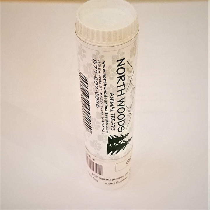 Tube of Northwoods paw balm standing with twist top upright on a white background. The white label has two pine trees next to the logo and type.