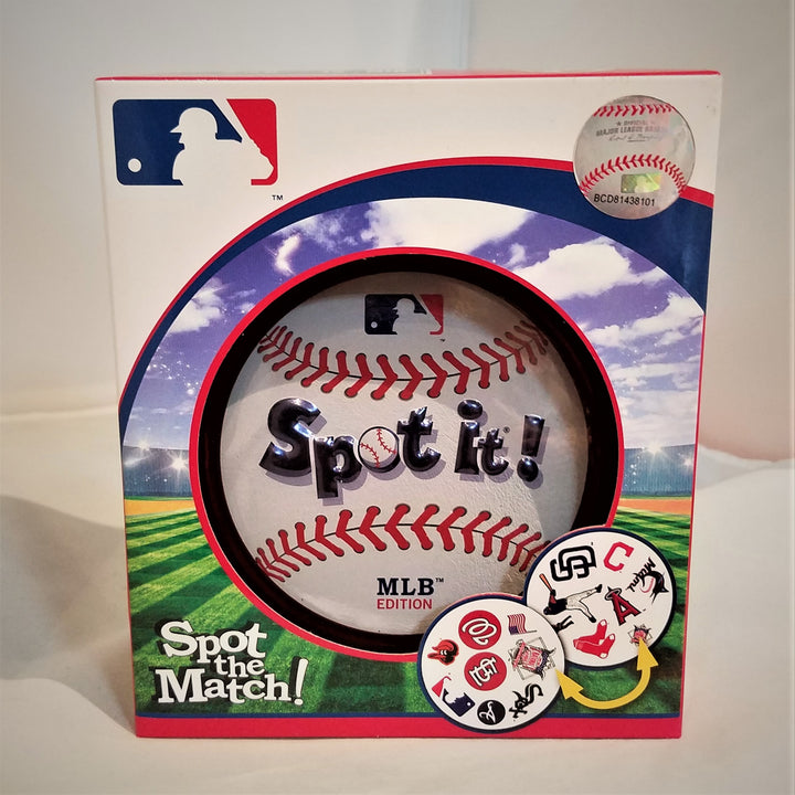 The front of the Spot It! box featruing a dummy baseball in the center surrounded by a bright green striped lawn underneath a dazzling blue clouded sky. Major league baseball logo and 2 circular patches on the bottom right with other baseball team logos depicted.