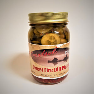 Glass jar of Sweet Fire Dill Pickles with lots of sliced pickles showing through the jar above the label under the gold screw top and a glimpse of red showing through under the label bottom.