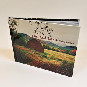 The Red Barn book standing upright with cover photo of an Adirondack autumn landscape with the Red Barn featured