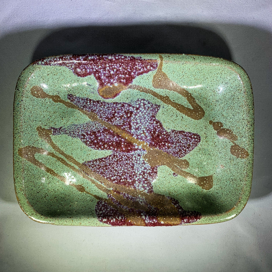 Ceramic tray in full, flat vertical orientation with deep rose, brown and green speckled glaze