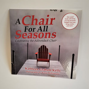 Cover of book a Chair for all Seasons puts a red Adirondack chair on a gray wooden pier set in a background of fof and water.
