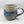 ceramic mug, blue speckled glaze on lower half and right-side handle with beige speckled glaze atop