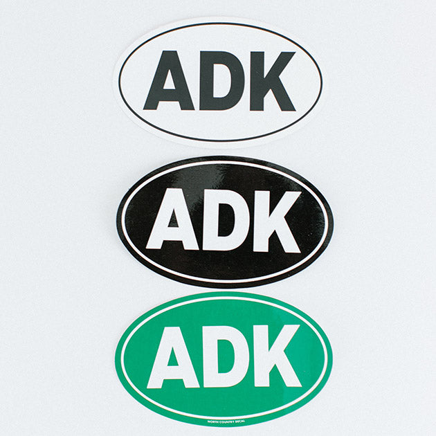 Top down, oval white sticker with black type; oval black sticker with white type; oval green sticker with white type