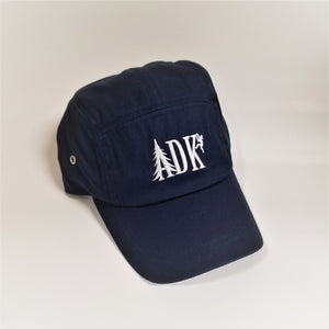ADK panel cap in navy with white embroidery featuring the letters ADK with the A in the style of a pine tree and a small hiker climbing the top of the K