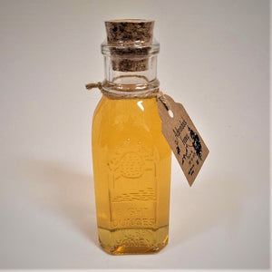 Single glass bottle of eight ounce size Adirondack Honey. Cork stopper top. Cord around the neck with the Adirondack Honey label hanging on the right.