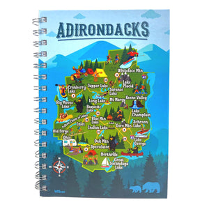 Spiralbound note book stands upright. The whole cover features the iconic cartoon Adirondack Park map. ADIRONDACKS is in dark blue type across the top. The borders are blue with mountains, clouds, trees, bears and a red and white directional compass. The interior is the full-color ADK Park map. Type is in white. Overall background is green. Lots of yellows, reds and blues in images.