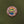 Close up of ADIRONDACK MOUNTAINS circular pin with colorful center circle depicting mountain, water and greenery. Outer circle has white type ADIRONDACK MOUNTAINS * NEW YORK. Pin is centered on the green card it is attached to.