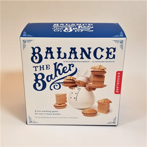 Blue and white box stands upright with Balance the Baker in blue typo next to and above a photo of the rounded baker holding tiny wooden pies and plates surrounded and 3 sets of wooden baked goods positioned around round baker bottom.