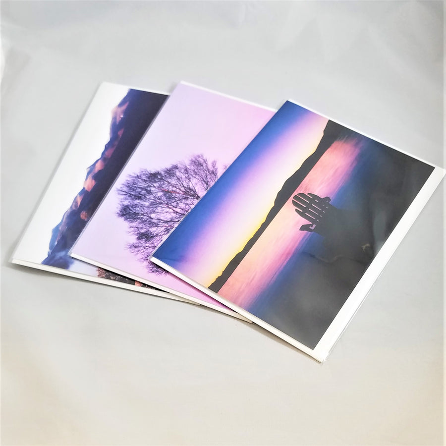 Three of photographer Barry Lobdell's Adirondack photo cards fanned out with Blue Sunset with Adirondack chair facing water and mountains on top.