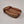Pack basket soap dish empty with red straps seen encircling the top of the basket and traveling down to the bottom end. Main basket looks like a straw weave.,