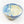 Inside and slight side view of ceramic bowl. Blue speckled glaze on left side, cream speckled glaze right side with blue on the outside right